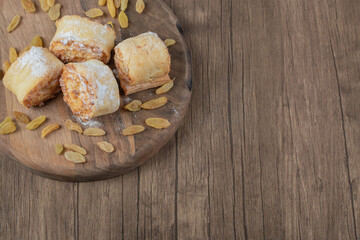Fried roll cookies with white raisins and sweet stuffings on a wooden board