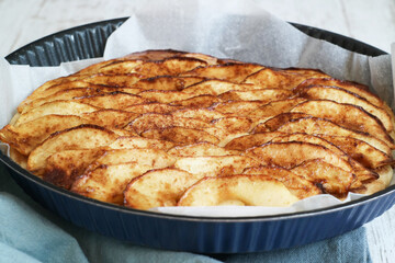 A baking tray of classic traditional French apple tart fine(tarte fine aux pommes) caramelized with brown sugar, made with butter puff pastry 