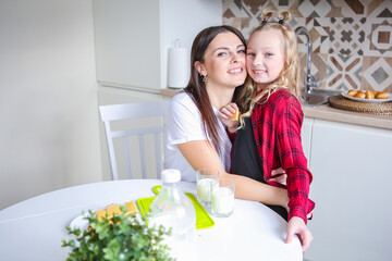 family, food and people concept - happy mother and daughter having breakfast at home