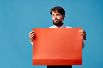 cheerful bearded man holding red banner blue background studio