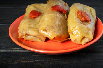 Cabbage rolls with beef, rice and vegetables on the plate. Stuffed cabbage leaves with meat. Black vintage table