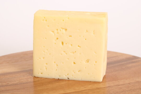 Ein gro&szlig;es St&uuml;ck K&auml;se auf einem Holzbrett