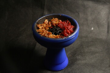 bowl of hookah tobacco. berries on a black background. shiisha smoking