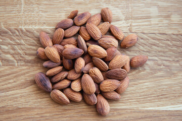 Crude almonds nuts on wooden background. Top view