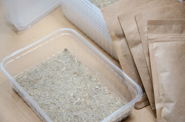 Fototapeta na wymiar Preparation for growing microgreens at home: linen substrate, seeds in packages and plastic bowls. Close up dry linen growing mat. Do it yourself. Step by step instructions. Selective focus. Step 1.