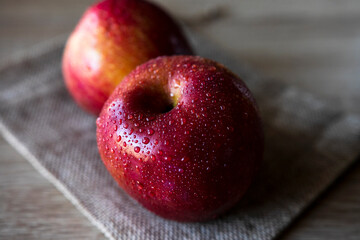 Photograph of two red apples on wooden table. Still life of food. 16: 9 photography. Freshness concept