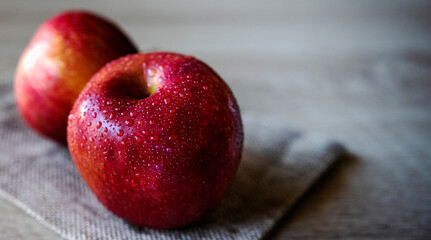 Photograph of two red apples on wooden table. Still life of food. 16: 9 photography. Freshness...