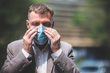 professional adult businessman wearing surgical face mask to protect of coronavirus covid-19,...