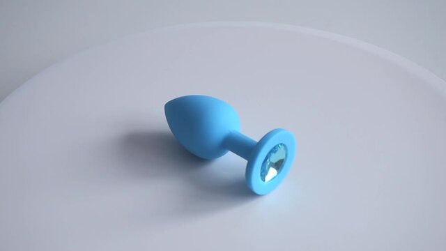 Blue anal plug spinning on white background