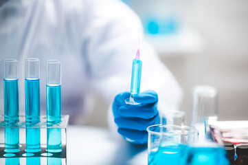 Researchers scientist working analysis with blue liquid test tube in the laboratory, chemistry science or medical biology experiment technology, pharmacy development solution
