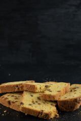 Sliced homemade roulette cake on dark background