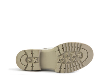 White leather boots with brown laces and zipper on the side. Imitation of crocodile skin. Beige rubber sole. Isolated close-up on white background. Shoe sole view. Fashion shoes.