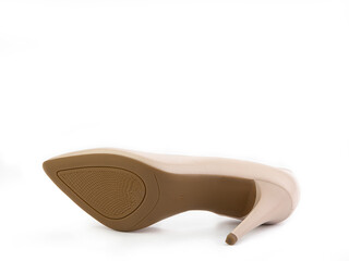 Classic and elegant high-heeled women shoes. Minimalist and stylish beige shoes on high heels. Isolated object close up on white background. Shoe sole view. Fashion shoes.