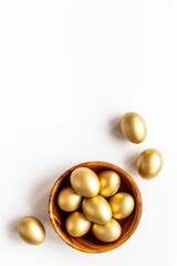 Golden Easter eggs in wooden bowl. Wealth and good luck concept.