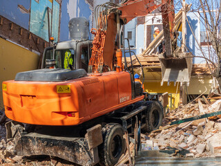 Demolishing an old house with a large excavator in this image of a street