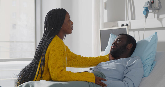 Afro-american wife visiting ill husband in hospital room