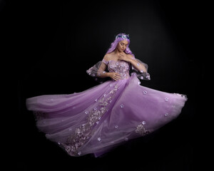 Full length portrait of girl wearing long purple fantasy ball gown with crown and pink hair,...