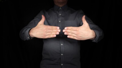 gesturing hands, man delimiting himself, setting limits, signs, gestures, isolated scene against black background 