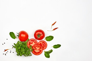 Fresh raw tomatoes and green herbs on white background with copy space. Organic vegetables on white
