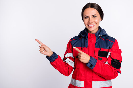 Photo of young woman paramedic happy positive smile indicate fingers empty space ad promo advice isolated over white color background
