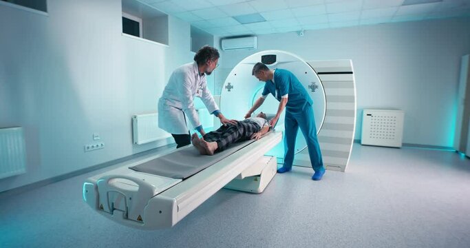 Male doctors making CT scan to senior patient