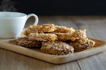 Thai sweet crispy fried rice and pour sugar, Thai call *Kao Tan* thai dessert and hot coffee in the wooden brown tray