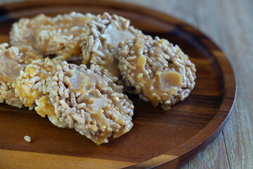 Thai sweet crispy rice and pour sugar, Thai call *Kao Tan* thai dessert in the wooden brown tray