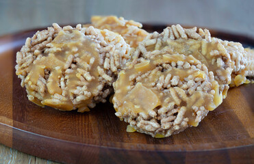 Thai sweet crispy rice and pour sugar, Thai call *Kao Tan* thai dessert in the wooden brown tray