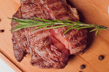 Large meat steak on the bone, grilled, served with grilled vegetables, corn, red onion, sweet...