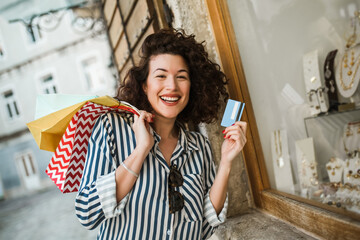 Happy curly hair woman shopping with her credit card.