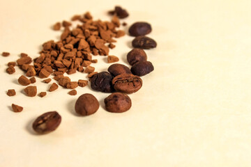 Granulated coffee and coffee beans are sprinkled on a beige background.