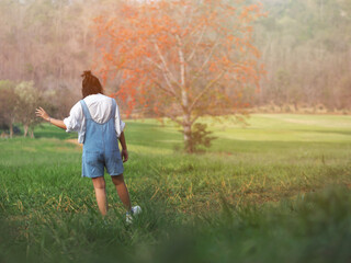 pretty girl walking and dancing through a green field, summer outdoor.