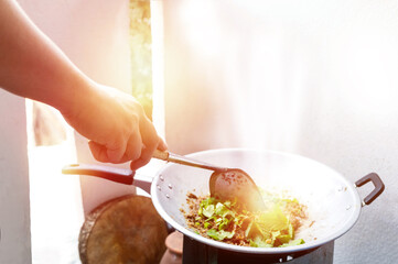 Chef is stirring vegetables in wok, The chef is cooking.