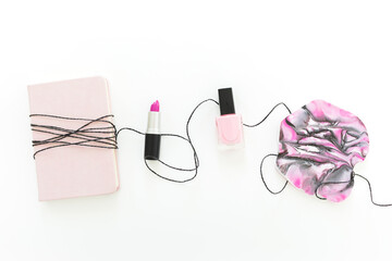 Pink resin art with diary, lipstick and nail polish on white background. Feminine concept. Flat lay