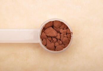 Kakao in Dosierlöffel auf braunem Hintergrund