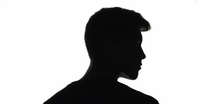 Male silhouette. Life choice. Challenge opportunity. Dark contrast back view outline of serious man turning head choosing way isolated on white empty space background.