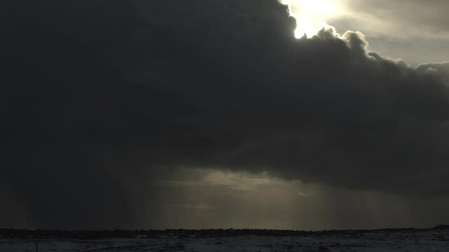 Birds flying under dark winter storm clouds cloudbreak Iceland winter