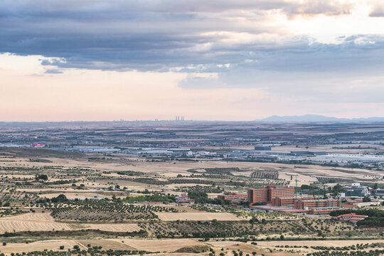 Panoramic Aerial View Of The New Hospital In Guadalajara With The Towers Of Madrid In The Background With Sky With Clouds And Yellow Tones In The Field