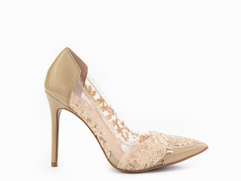 Elegant and stylish high-heeled women shoes. Beige lacquered shoes on high heels with beautiful lace details and glitters. Isolated close-up on white background. Right side view. Fashion shoes.