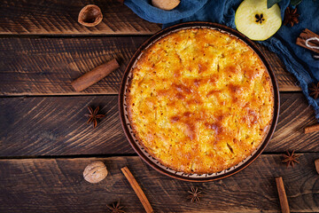 Delicious homemade apple pie on wooden background. Apple pie with ingredients, apples and cinnamon. Top view