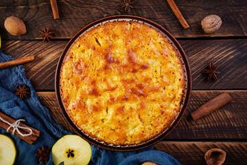 Delicious homemade apple pie on wooden background. Apple pie with ingredients, apples and cinnamon. Top view