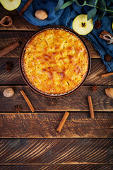 Delicious homemade apple pie on wooden background. Apple pie with ingredients, apples and cinnamon. Top view