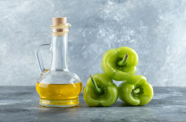 Stack of sweet peppers with bottle of oil