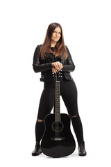 Female rock musician with acoustic guitar wearing a black leather jacket