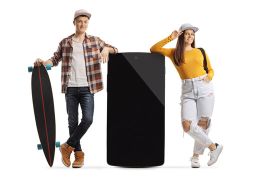 Young male with a longboard and female leaning on a big mobile phone