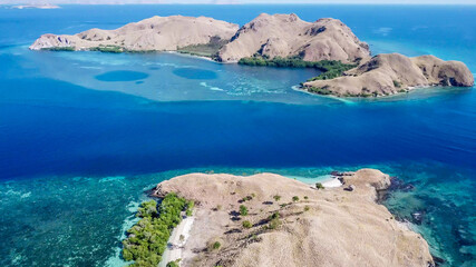 A drone shot of two bigger paradise islands in Komodo National Park, Flores, Indonesia. The islands...