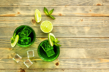 Glasses of iced mojito or lemonade with lime and mint