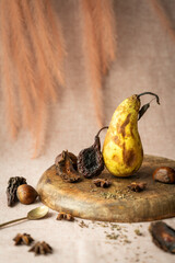 chestnuts and dried pear wedges and a very ripe pear with brown spots were arranged in a still life
