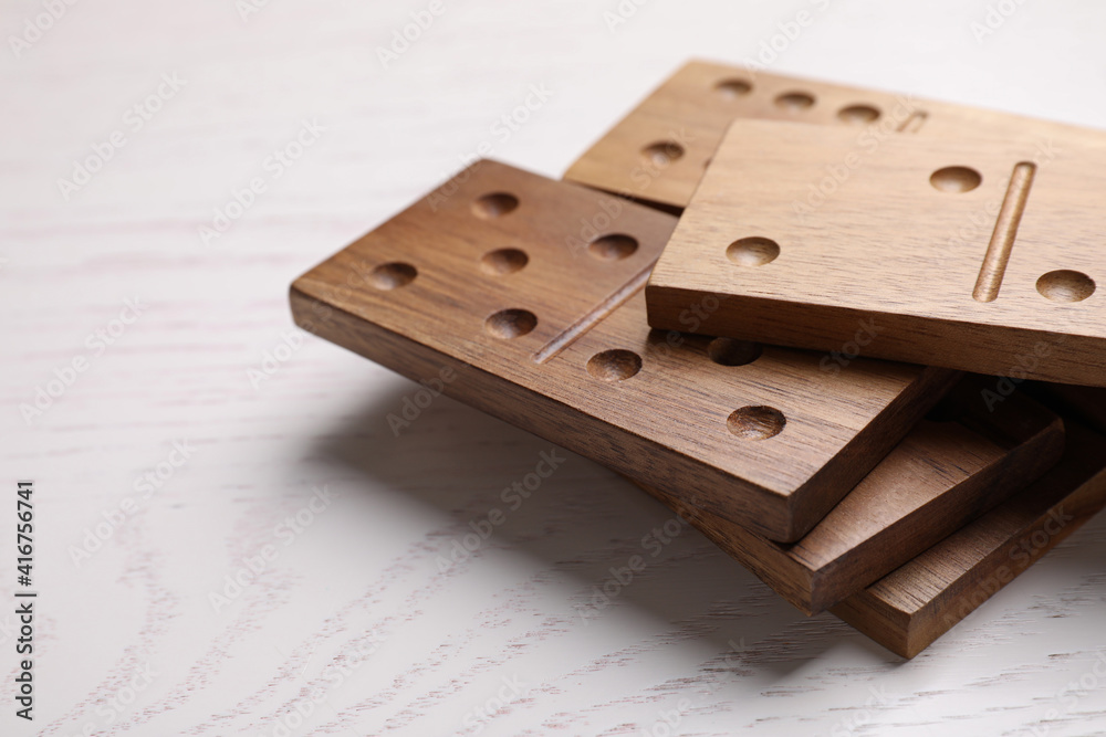 Sticker Wooden domino tiles on white table, closeup