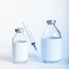 Vaccines glass bottles. Medicine glass botttles and syringe on a white.